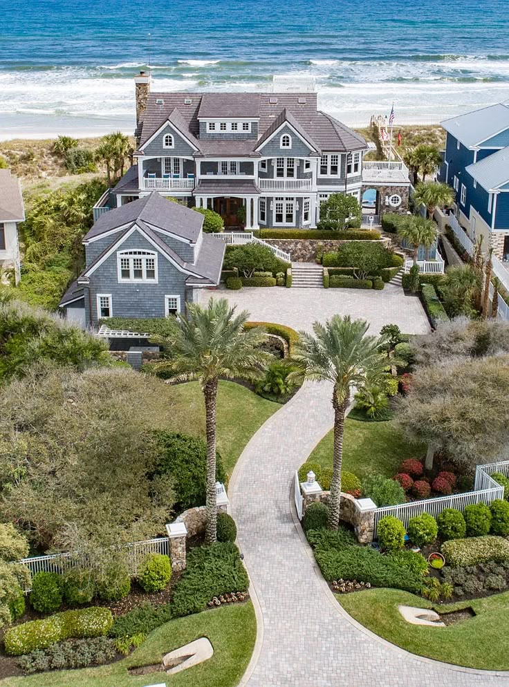 this is an aerial view of the house and its surrounding grounds, with ocean in the background