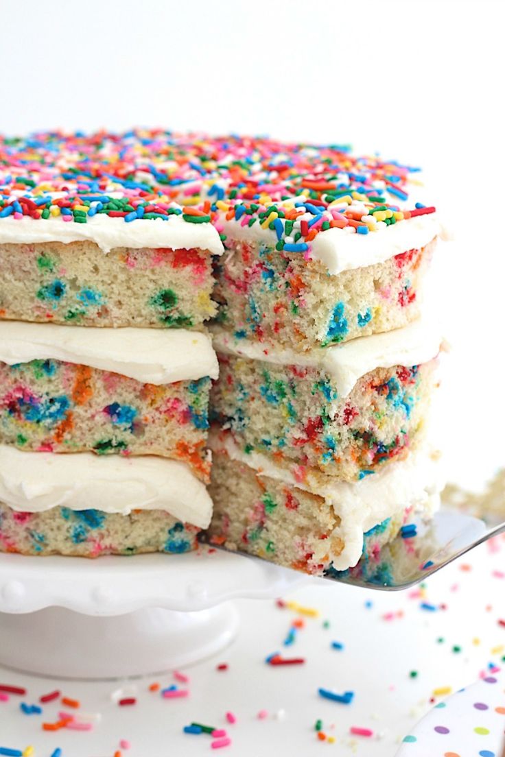 a cake with white frosting and colorful sprinkles