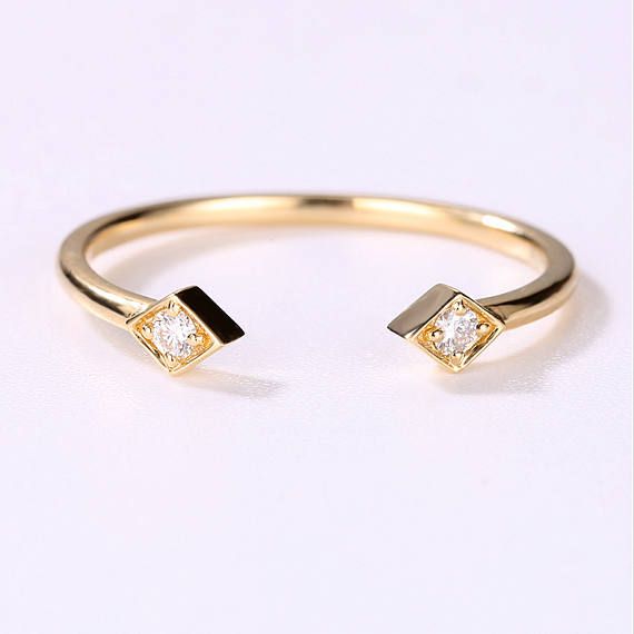 a gold ring with two diamonds on it