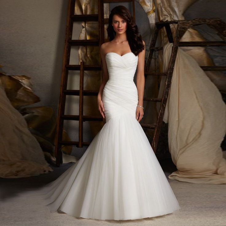 a woman in a wedding dress posing for the camera