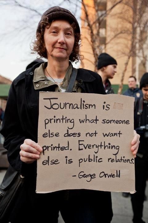 a woman holding a sign that reads journalist is printing what someone else does not want printed everything else is public relations