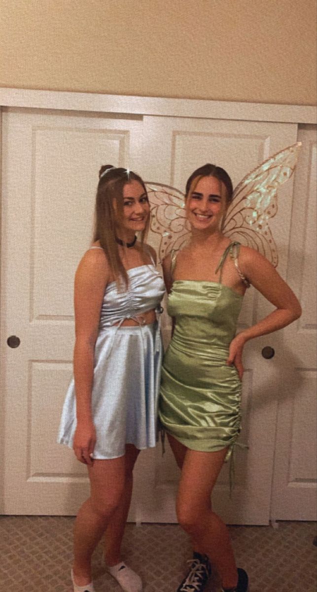 two girls dressed up in fairy costumes posing for the camera