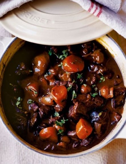 a pot filled with stew and carrots on top of a table