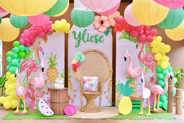 a tropical themed birthday party with flamingos, pineapples, and paper lanterns