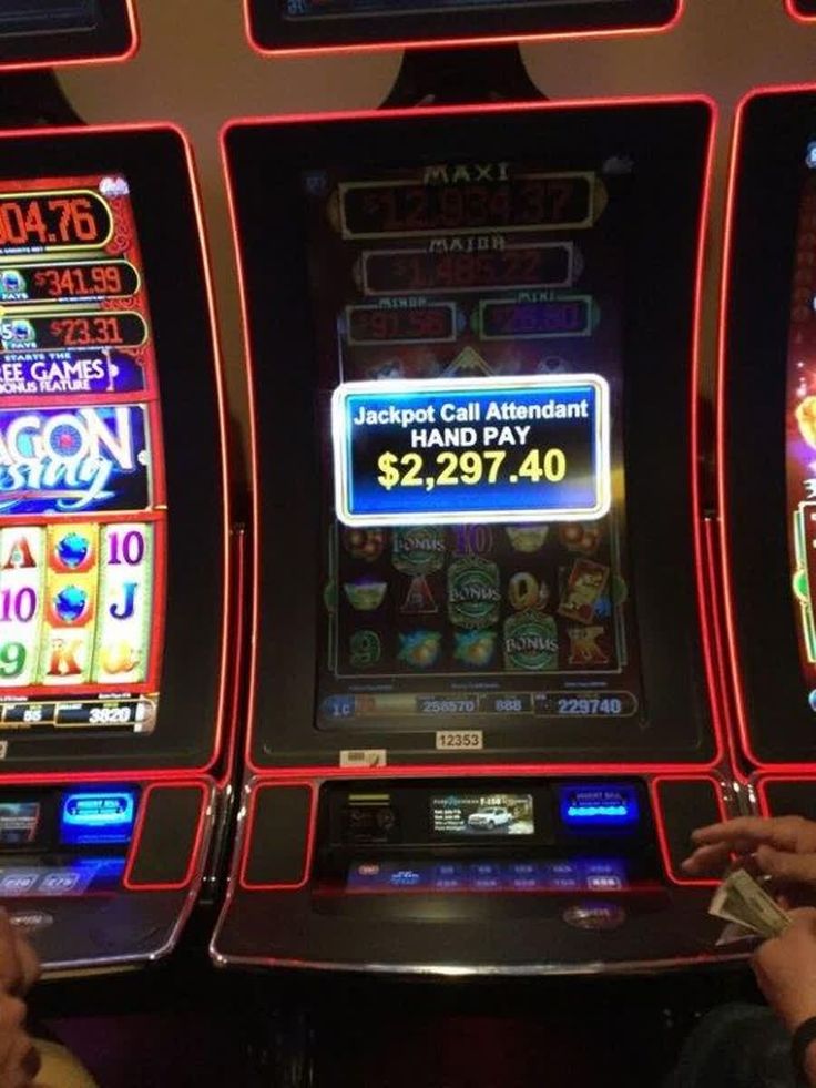 two people playing slot machines in a casino