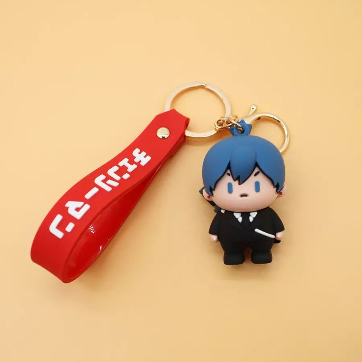 a keychain shaped like an anime character with a red toothbrush attached to it