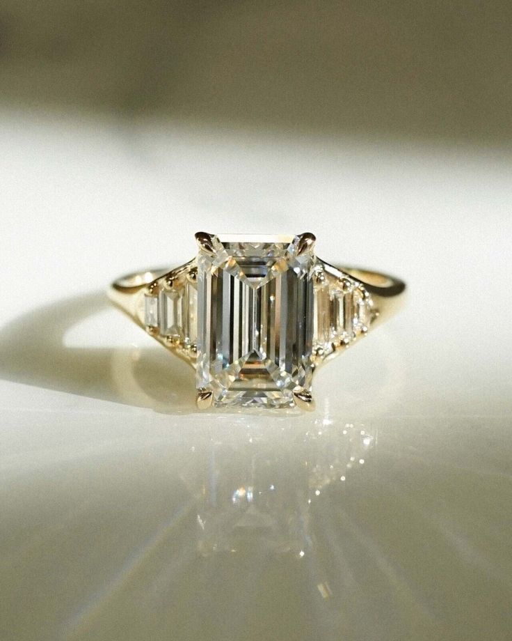 an emerald cut diamond ring with three baguets