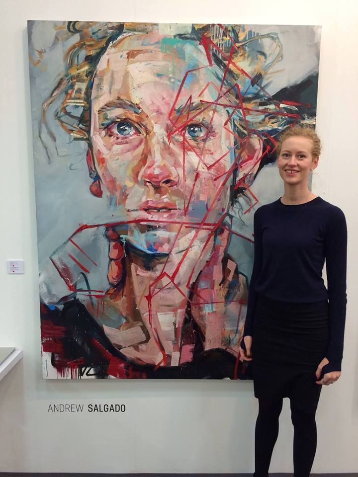 a woman standing in front of a painting