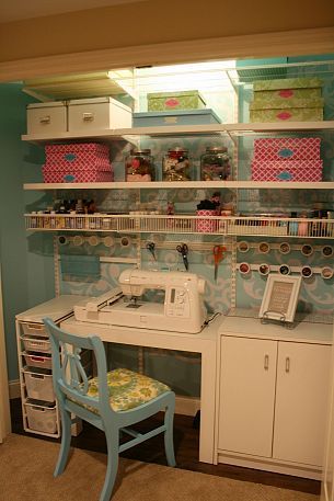 a sewing machine sitting on top of a white desk next to a chair and shelf