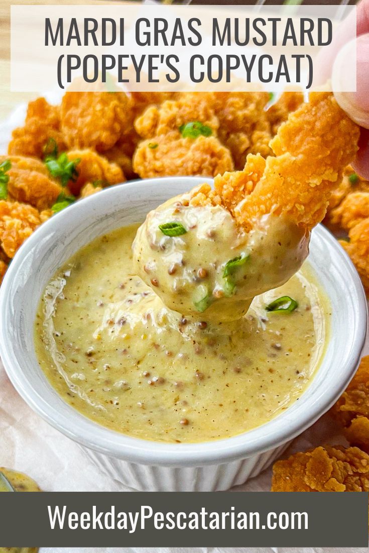 a person dipping some food into a bowl with chicken nuggies on the side