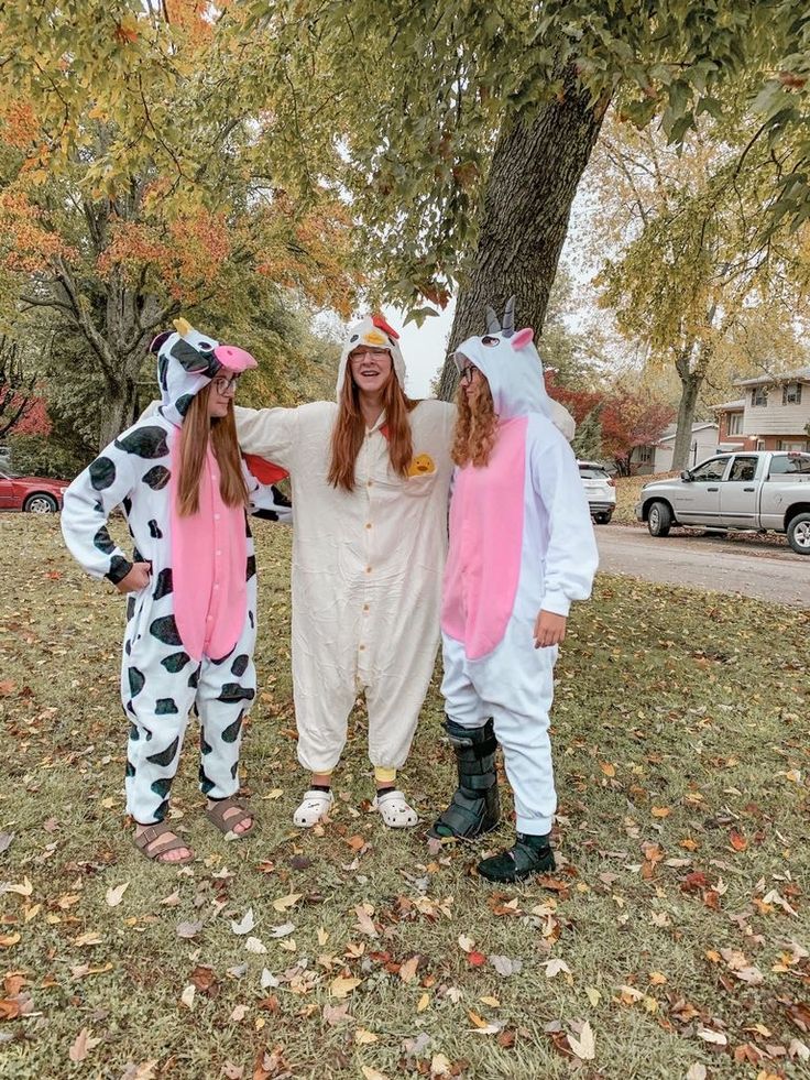 three people in costumes standing under a tree