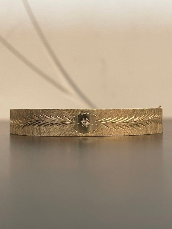 This stunning 14K yellow gold hinged bangle bracelet has beautiful engraving work on it.  It has a flower on each side and gorgeous etching around the entire bangle.  This bracelet is in excellent condition and weighs 13.8 grams. Antique 14k Gold Bracelet Engraved, Antique Engraved 14k Gold Bracelet, Victorian Gold Wedding Bracelet Stamped 14k, Elegant Etched Bangle For Wedding, Victorian Gold Bracelet For Wedding, Antique Engraved Yellow Gold Cuff Bracelet, Vintage Yellow Gold Engraved Cuff Bracelet, Antique Engraved Yellow Gold Bracelet, Heirloom 14k Gold Engraved Bangle