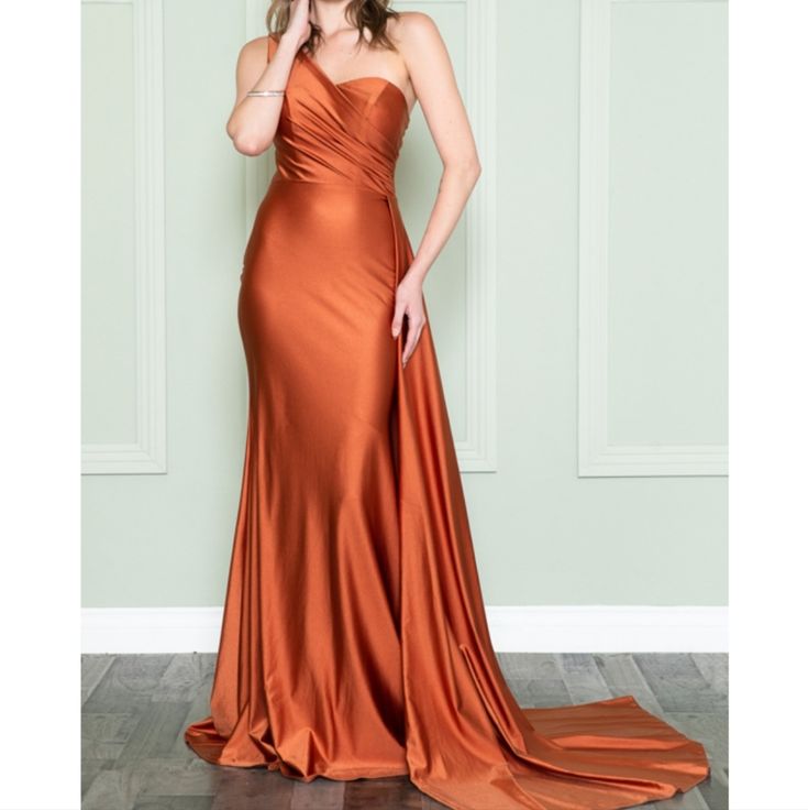 This Mattified Stretch Sexy Piece Flaunts An Asymmetrical One Shoulder Neckline With Sweetheart Shaped Bust, Ruched Fitted Bodice Paired With A Mid-Open Back. The Ravishing Sheath Skirt Tapers To Full Length With Floor Sweeping Train That Dramatically Goes Perfectly With The Side Overlay Drape Accent. Color: Burnt Orange Pre-draped One Shoulder Evening Dress With Sweep Train, Party Gown With Ruched Bodice And Asymmetrical Neckline, Fitted Evening Dress With Asymmetrical Neckline, Asymmetrical Evening Dress With Ruched Bodice, Party Gown With Pre-draped Asymmetrical Neckline, Asymmetrical Maxi Dress With Ruched Bodice For Gala, Pre-draped Asymmetrical Evening Dress For Gala, Fitted Evening Dress With Asymmetrical Neckline For Prom, Asymmetrical Party Evening Dress With Ruched Bodice