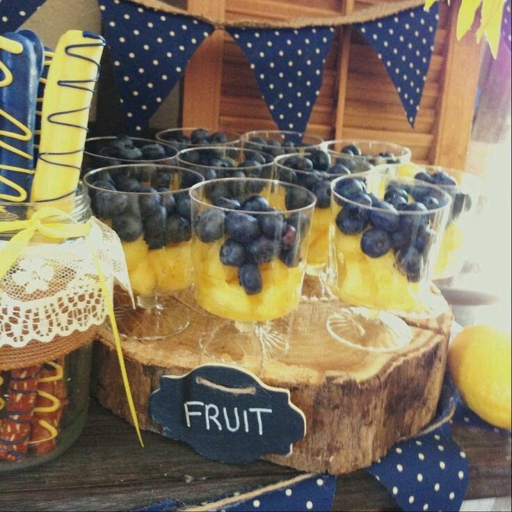 blueberries and lemons are arranged in glasses on a table with other fruit items