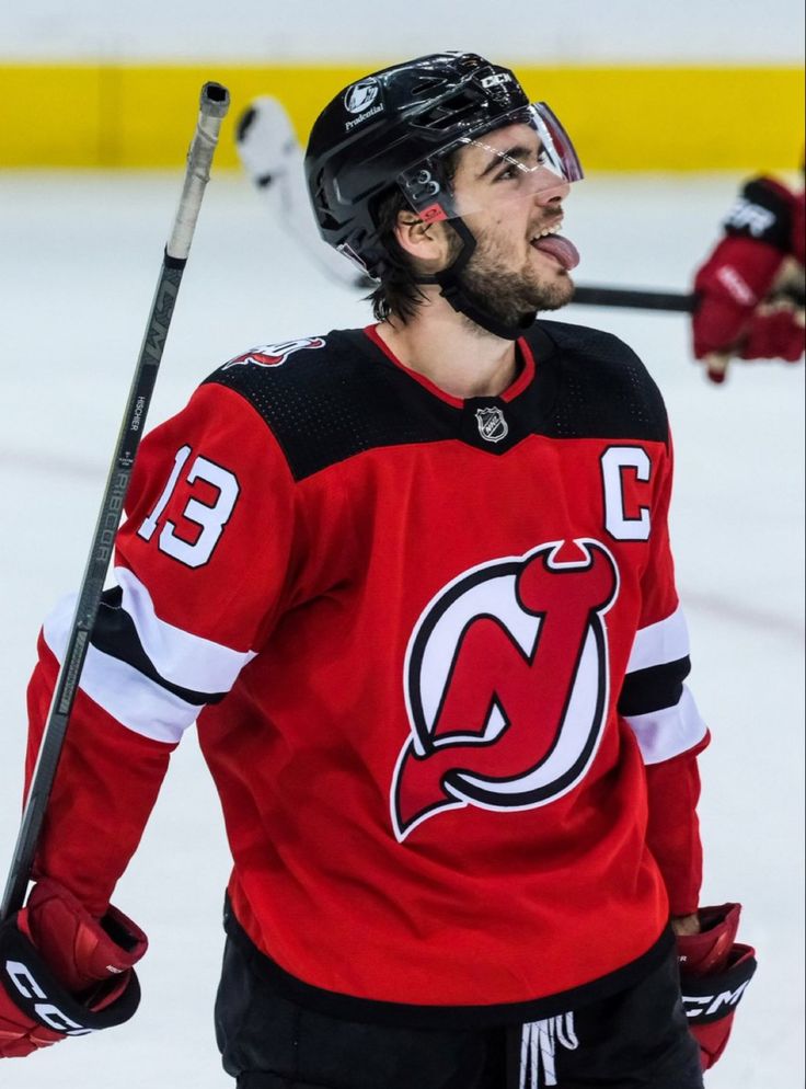 the hockey player is making a face while holding his stick