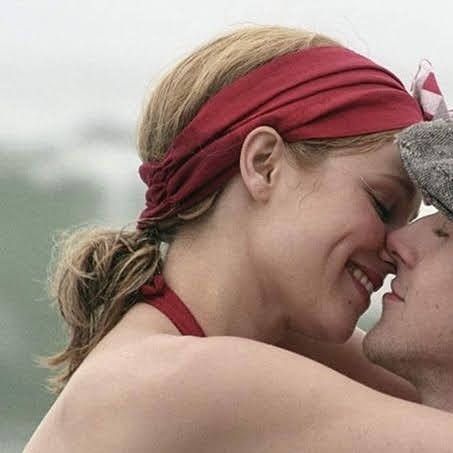 a man and woman embracing each other on the beach