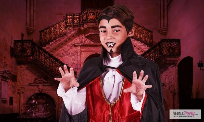 a boy dressed in dracula costume with his hands out to the side and mouth open