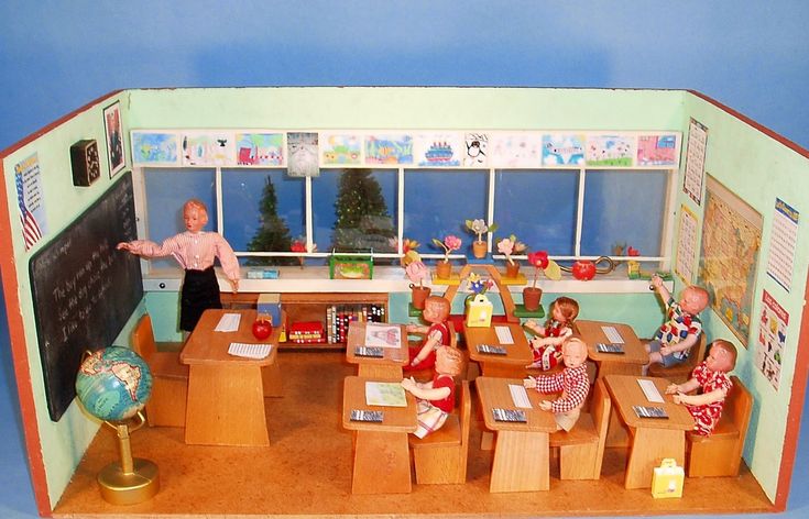 there are many dolls sitting at desks in the room with their teacher's books