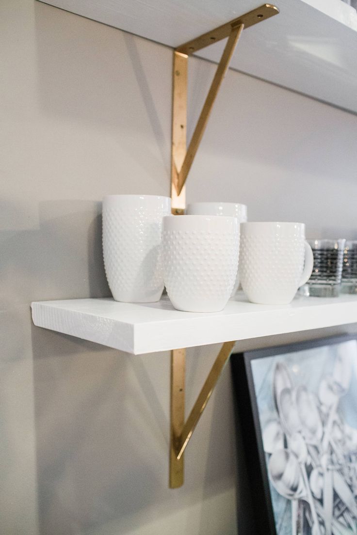 white cups are lined up on a shelf