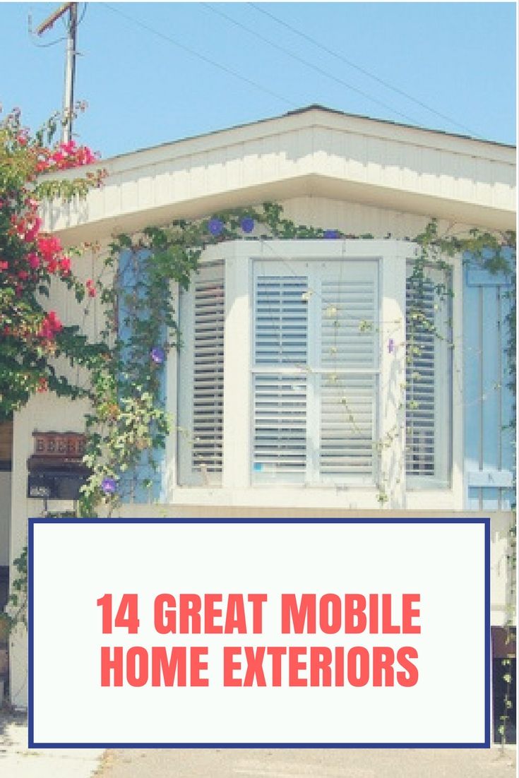 the front of a house with white shutters and flowers growing on it's windows