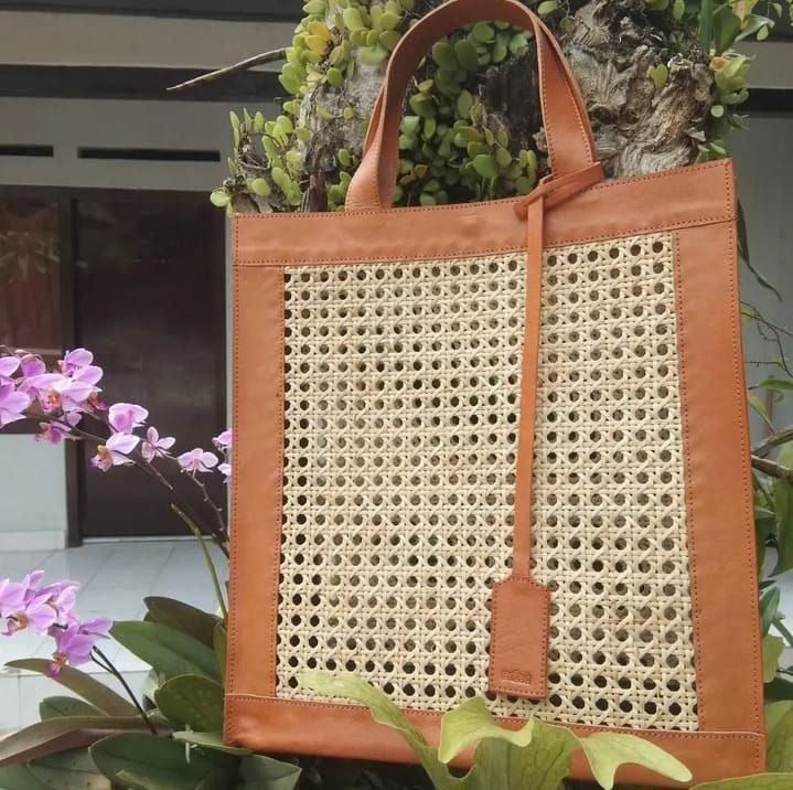 Versatile and lightweight, this rattan and leather bag offers both durability and a natural texture, perfect for daily errands or casual outings. Free shipping on all rattan and leather bags. Tall rattan cane webbing and leather tote shoulder bag, designed for ease of use and spacious enough for daily essentials. Handcrafted using a six-way rattan weave and durable cowhide leather, providing structure and longevity. Made in Bali, known for high-quality rattan and premium cowhide leather craftsmanship. Dimensions: 12.5" H x 11.5" L x 4" D inches. Cane webbing and genuine leather with reinforced edges for a refined, sturdy finish. Features a snap closure for secure storage. Interior lined with soft batik fabric, ensuring privacy for your belongings. Strong leather handles for comfortable sho Metallic Cowhide Rug, Cane Webbing, Brindle Cowhide, Patchwork Cowhide Rug, Rattan Cane, Earthy Aesthetic, Rattan Weave, Leather Waist Bag, Leather Toiletry Bag