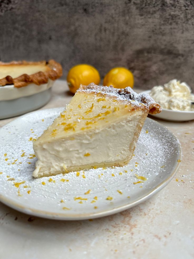 a slice of pie on a plate with lemons in the background