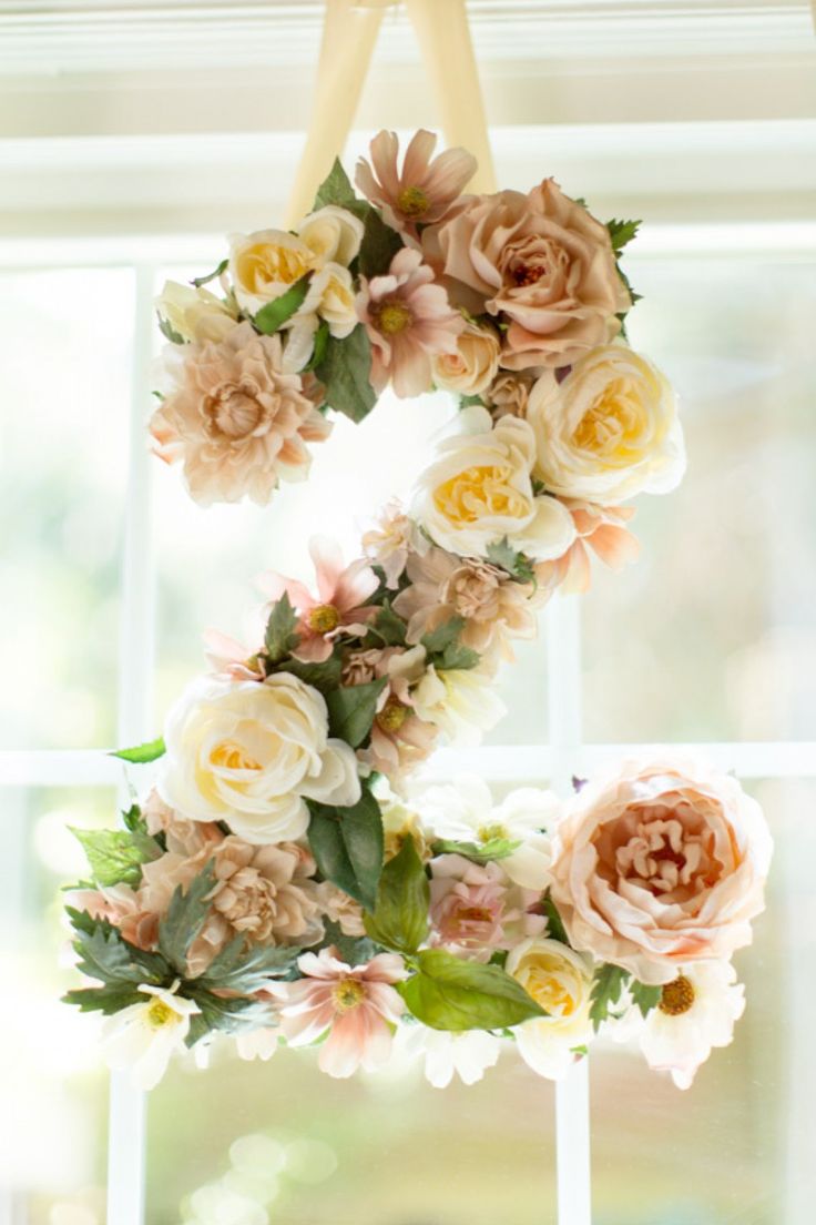 a wreath made out of flowers hanging from a window sill