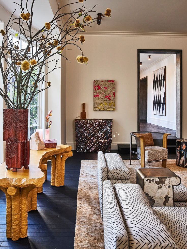 a living room filled with furniture and a tall vase on top of a wooden table