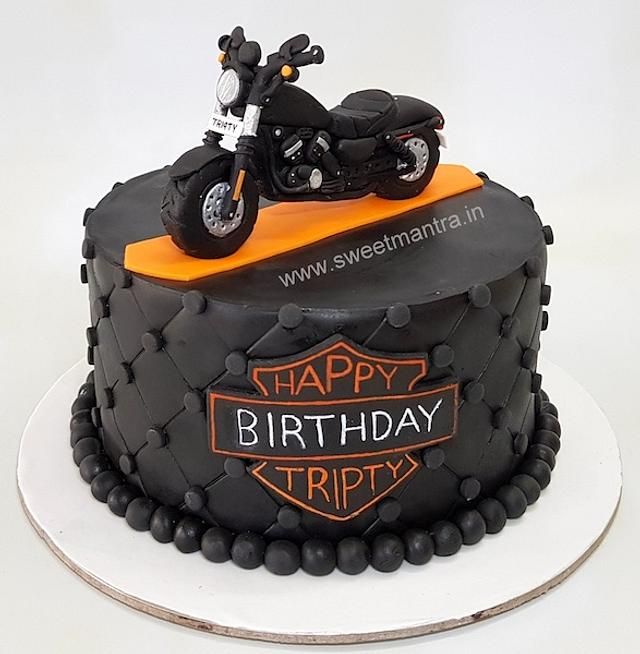 a black and orange birthday cake with a motorcycle on top