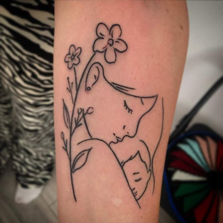 a woman's arm with a flower and an elephant tattoo on the left side