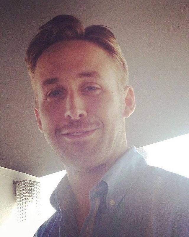 a man is smiling for the camera while wearing a button up shirt and tie with his hair in a bun