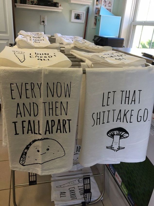 towels with funny sayings on them are hanging from a rack in a kitchen area