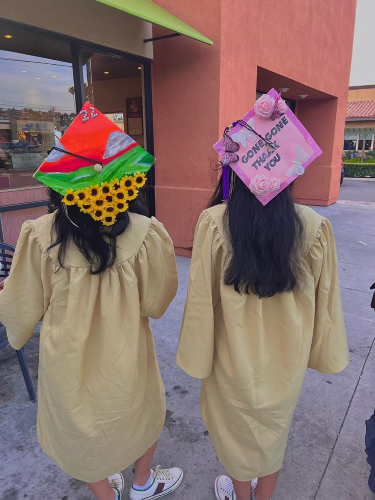 two girls in graduation gowns with hats on their heads