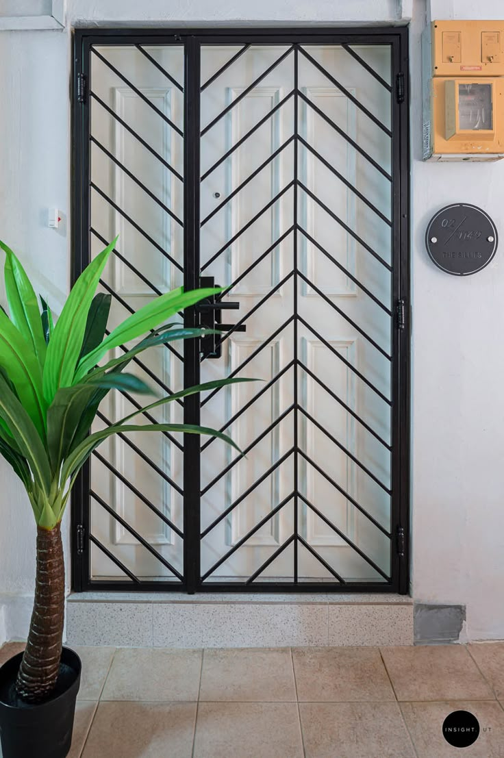 a potted plant sitting in front of a glass door on the side of a building