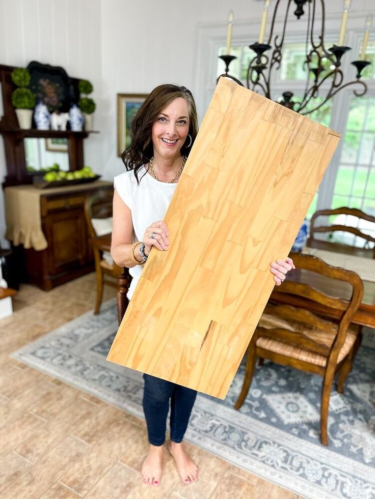 a woman holding up a large piece of wood