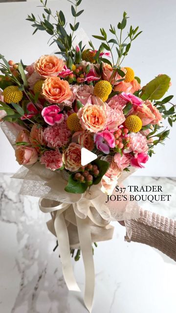 a bouquet of flowers sitting on top of a marble counter next to a white wall