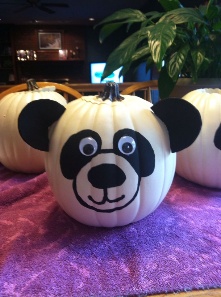 three panda face pumpkins sitting on a table