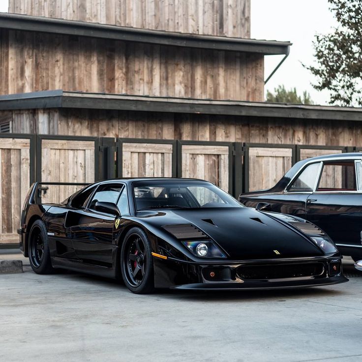 two black sports cars parked next to each other