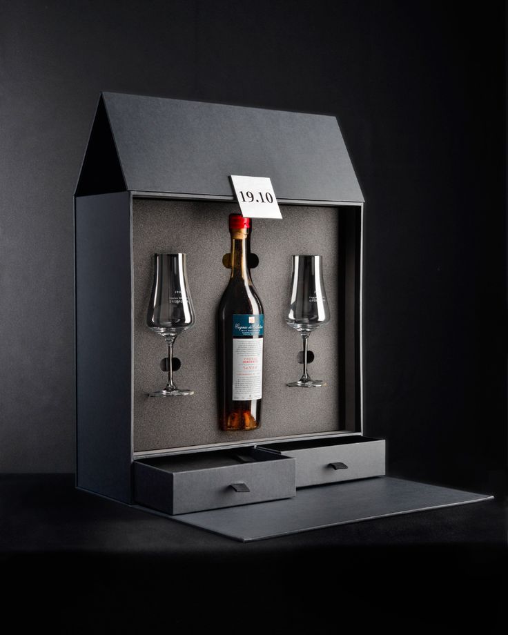 a bottle of wine and two glasses in a black box with a note on it