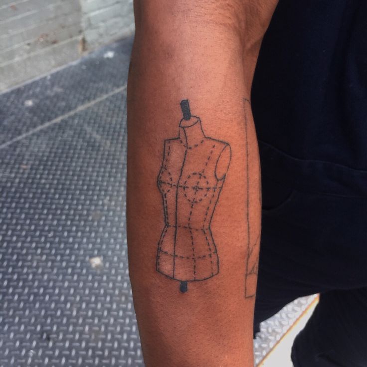 a person with a tattoo on their arm that has a dressmaker's mannequin