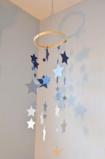 a baby crib with blue and white stars hanging from it