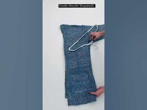 a person is using a hook to tie something on the back of a blanket that has been knitted