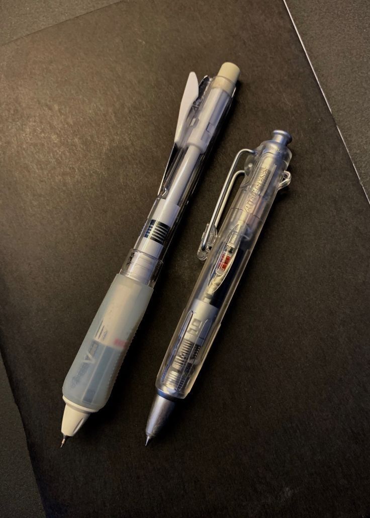 two pens sitting next to each other on top of a table