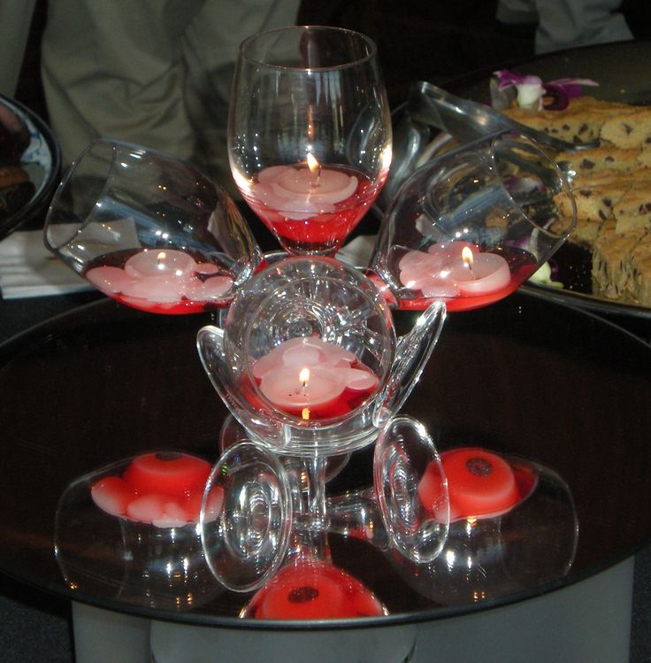 a table topped with wine glasses filled with red liquid and desserts on top of it