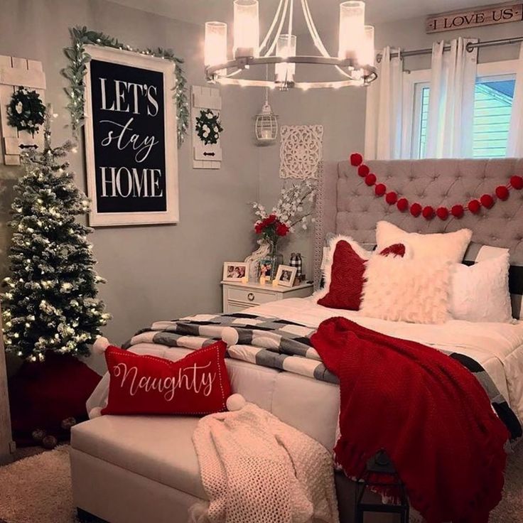 a bedroom decorated for christmas with red and white decorations on the walls, bedding, and pillows