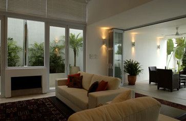 a living room filled with furniture next to a dining room table and large glass windows