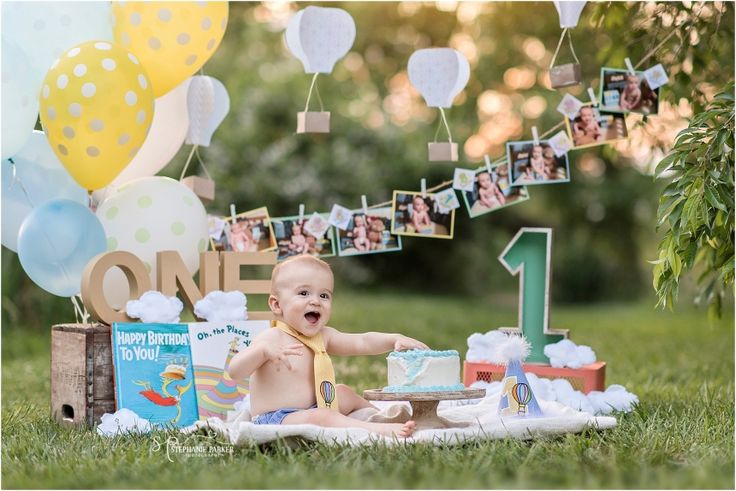 a baby is sitting in the grass with his first birthday cake