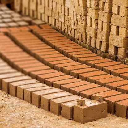 bricks laid out on the ground in front of a brick wall