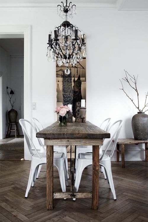 a dining room table with white chairs and a chandelier