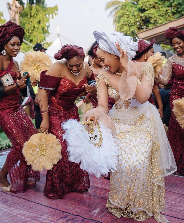 a group of women dressed in red and gold dresses dancing on a dancefloor